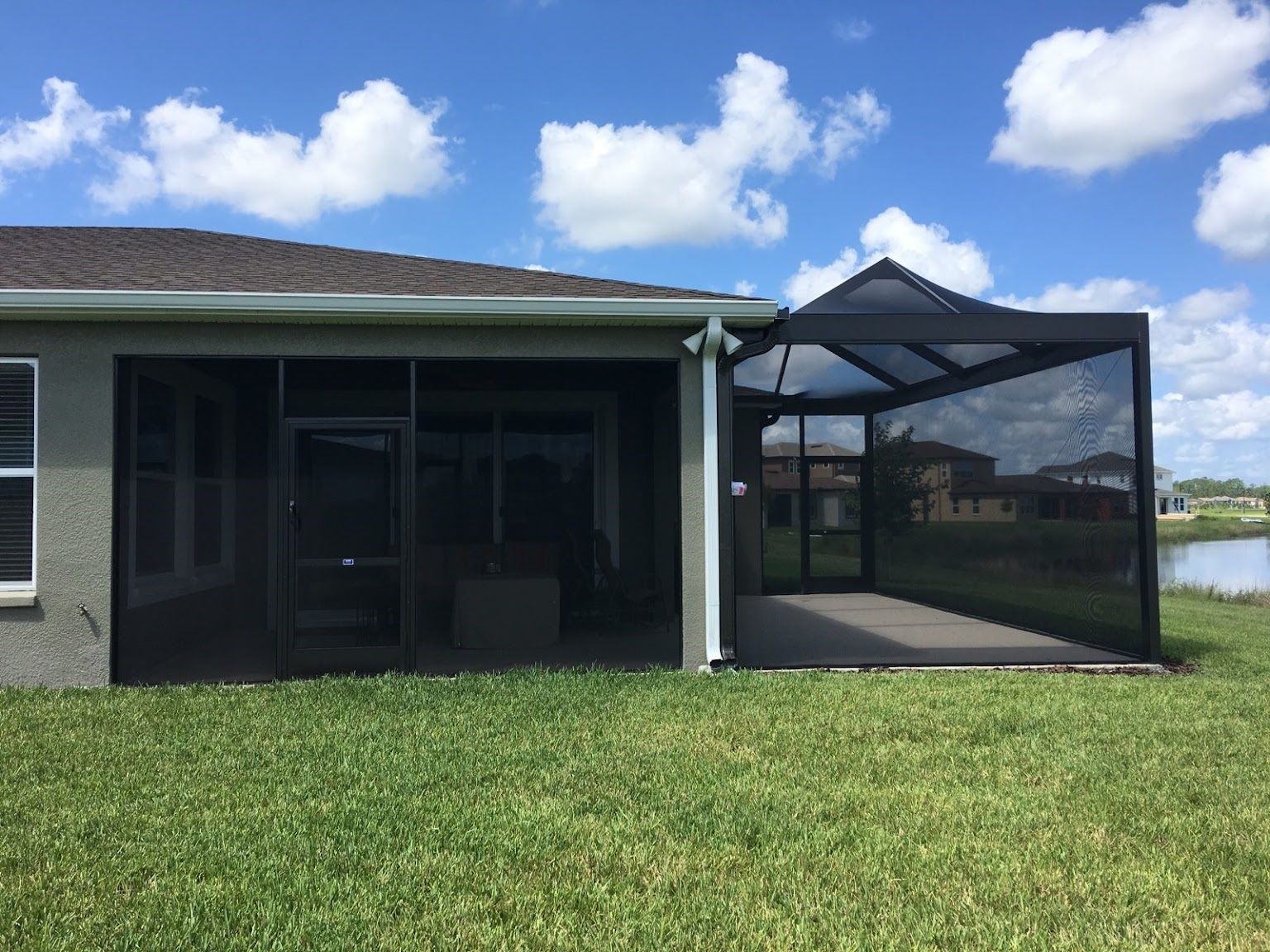 The back of a house with a screened in porch.