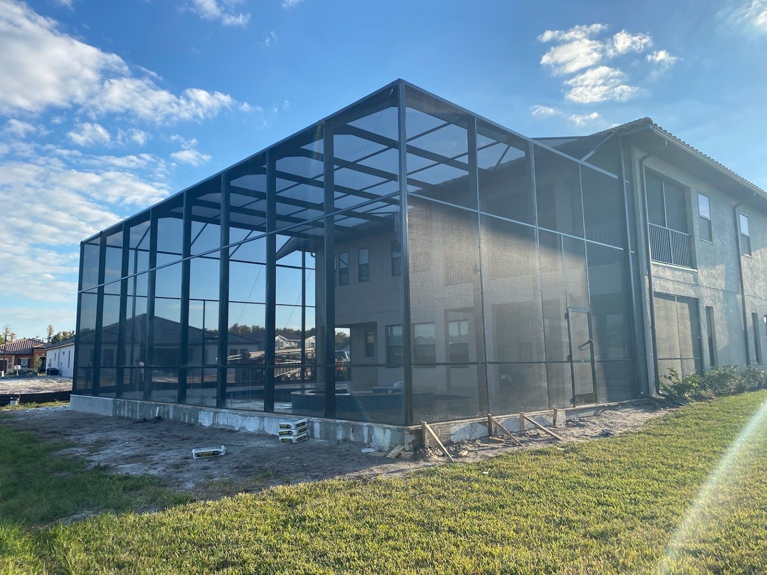 A large screened in porch is being built on the side of a house.
