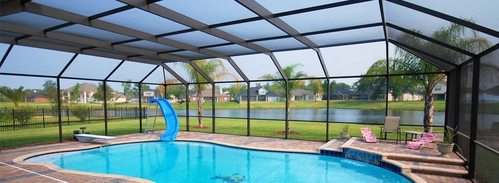 A screened in swimming pool with a slide in it