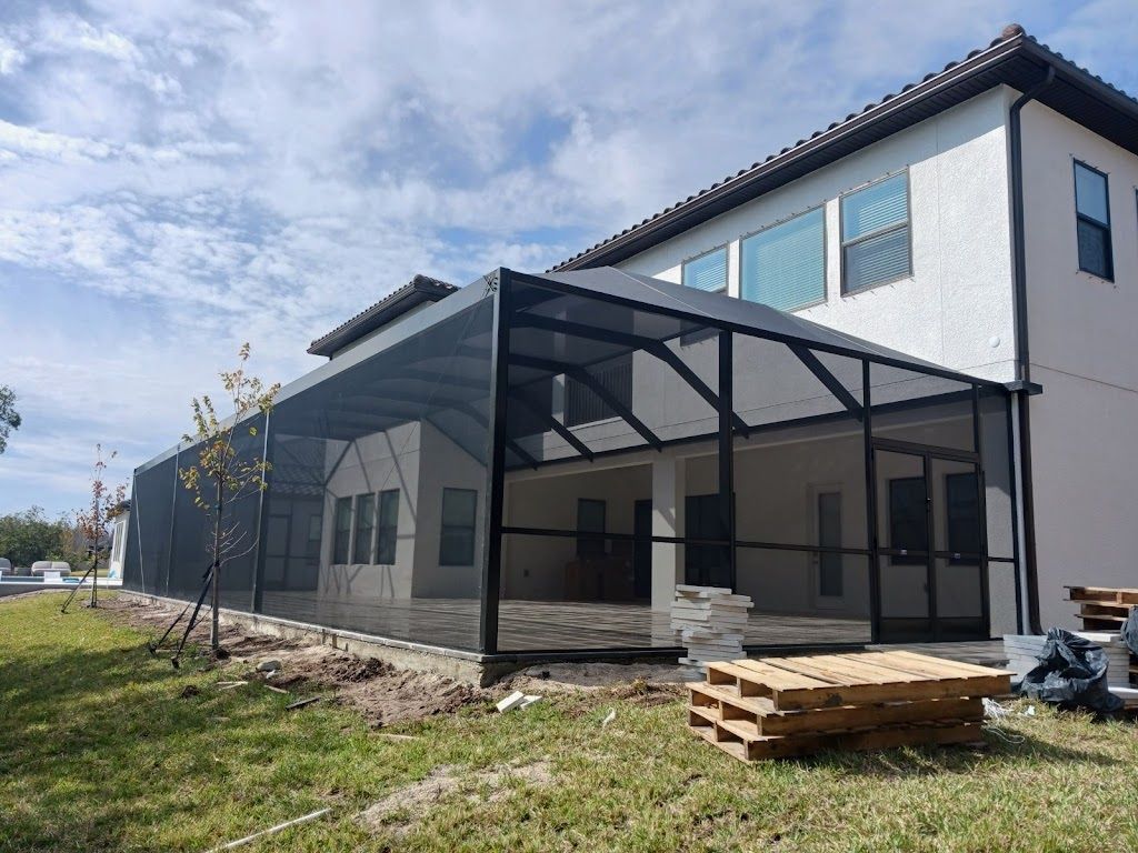 A screened in porch is being built in the backyard of a house.