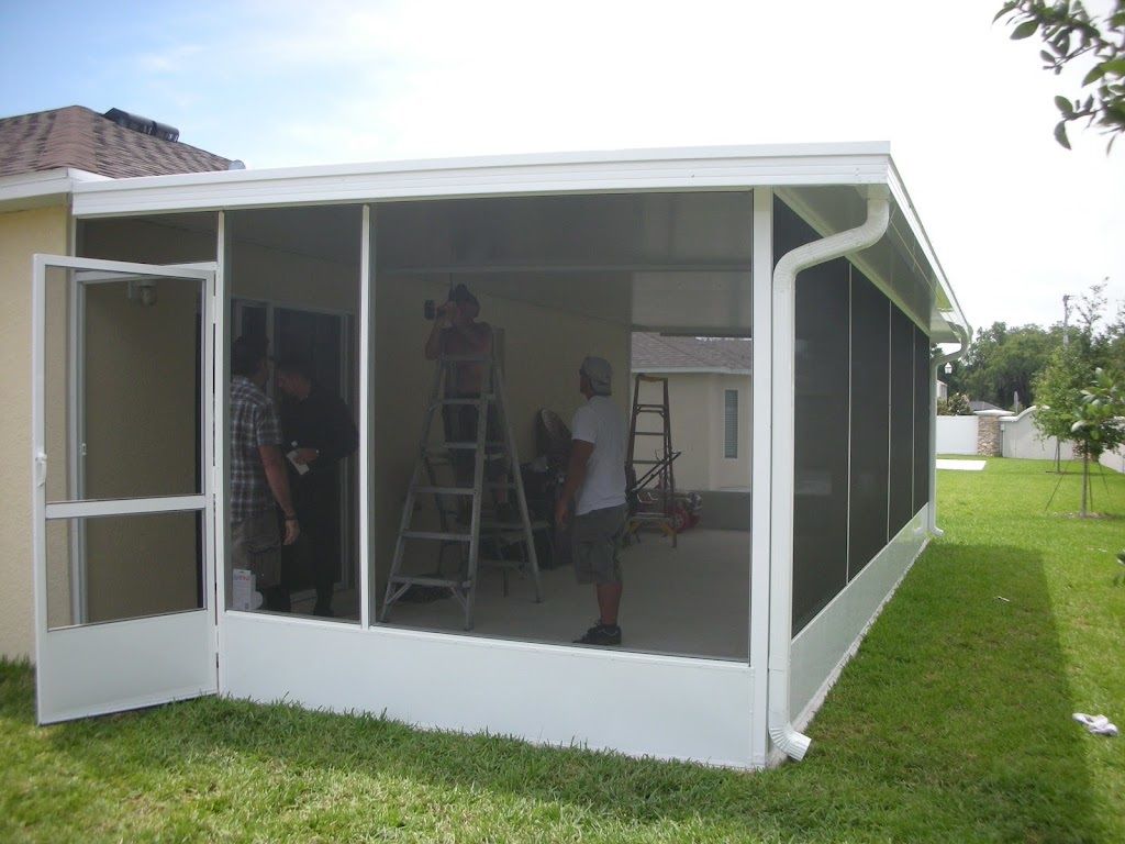 A screened in porch is being built in the backyard of a house