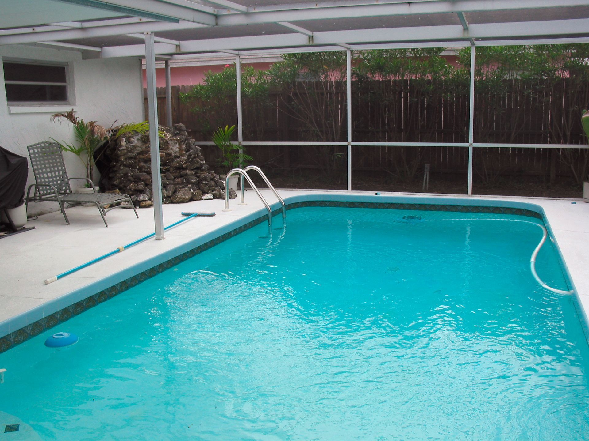 A large swimming pool with a screened in area