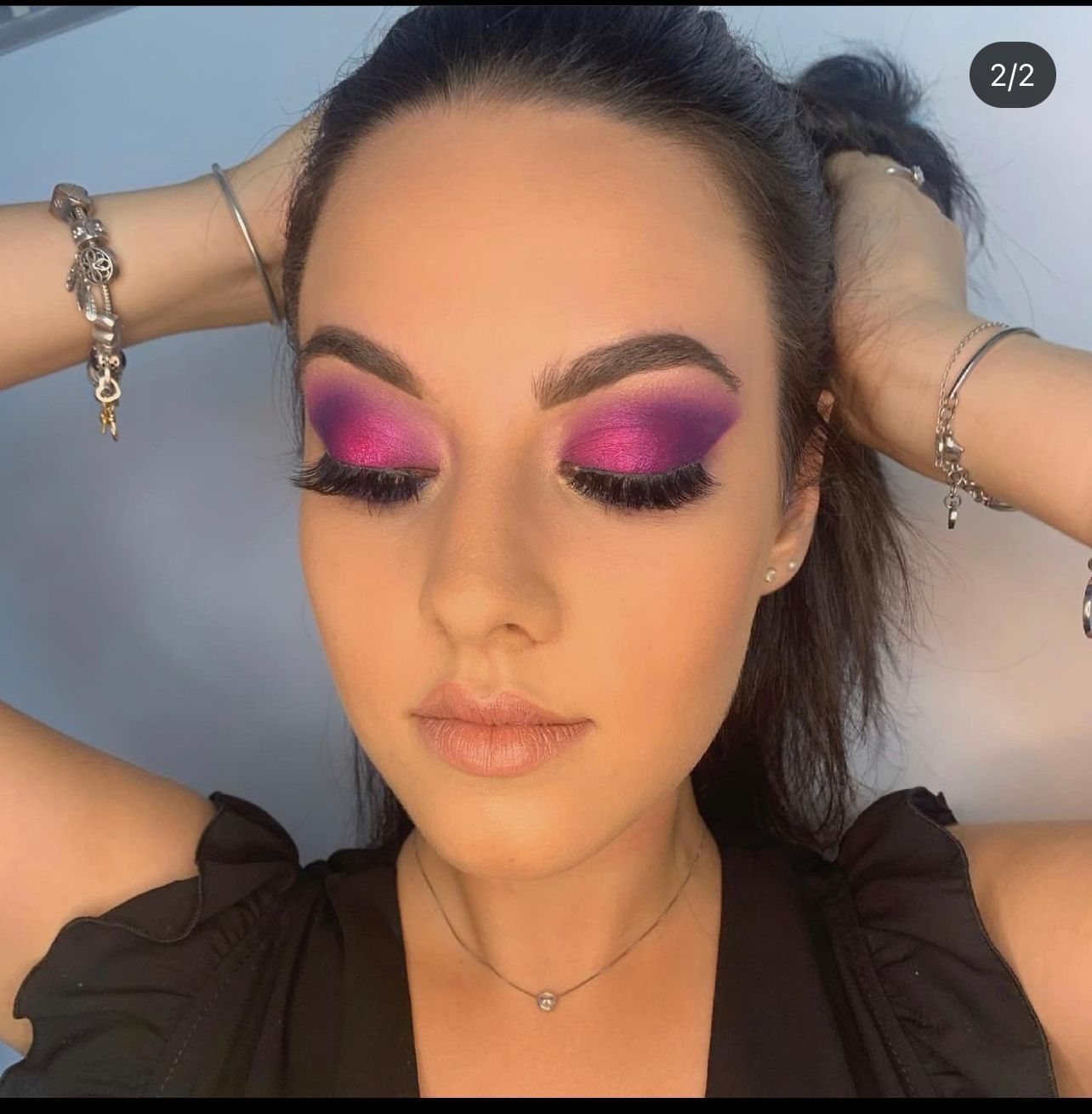 Woman wearing purple and fuchsia eye shadow with false eyelashes