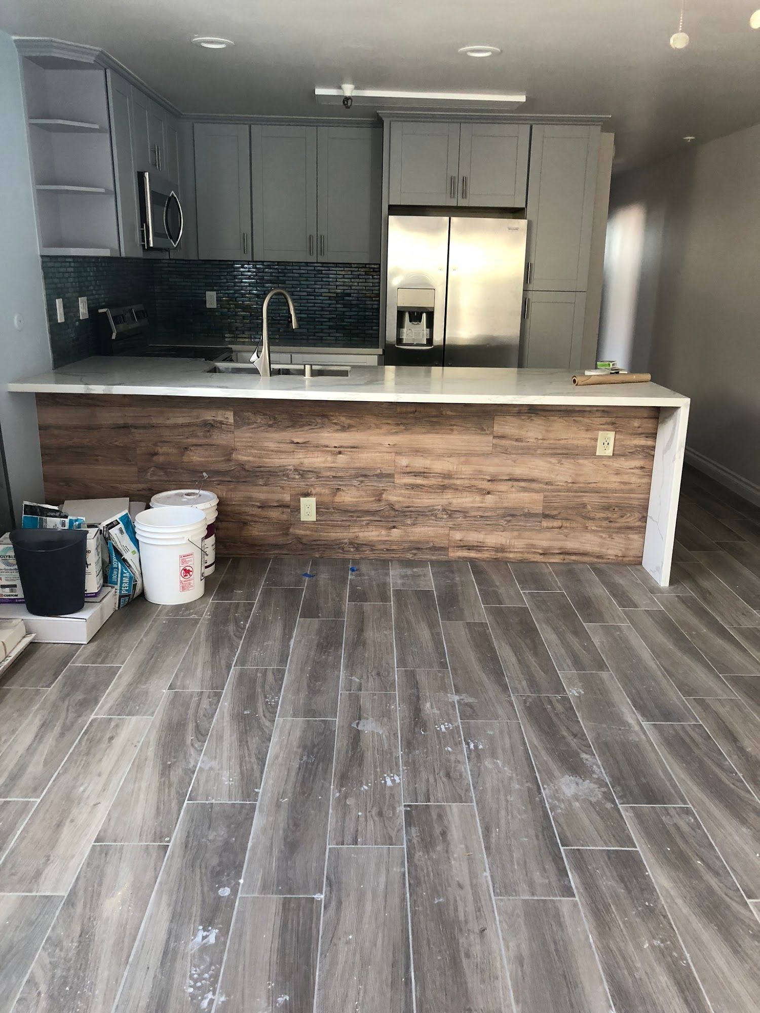 A kitchen with a wooden counter top and a stainless steel refrigerator.