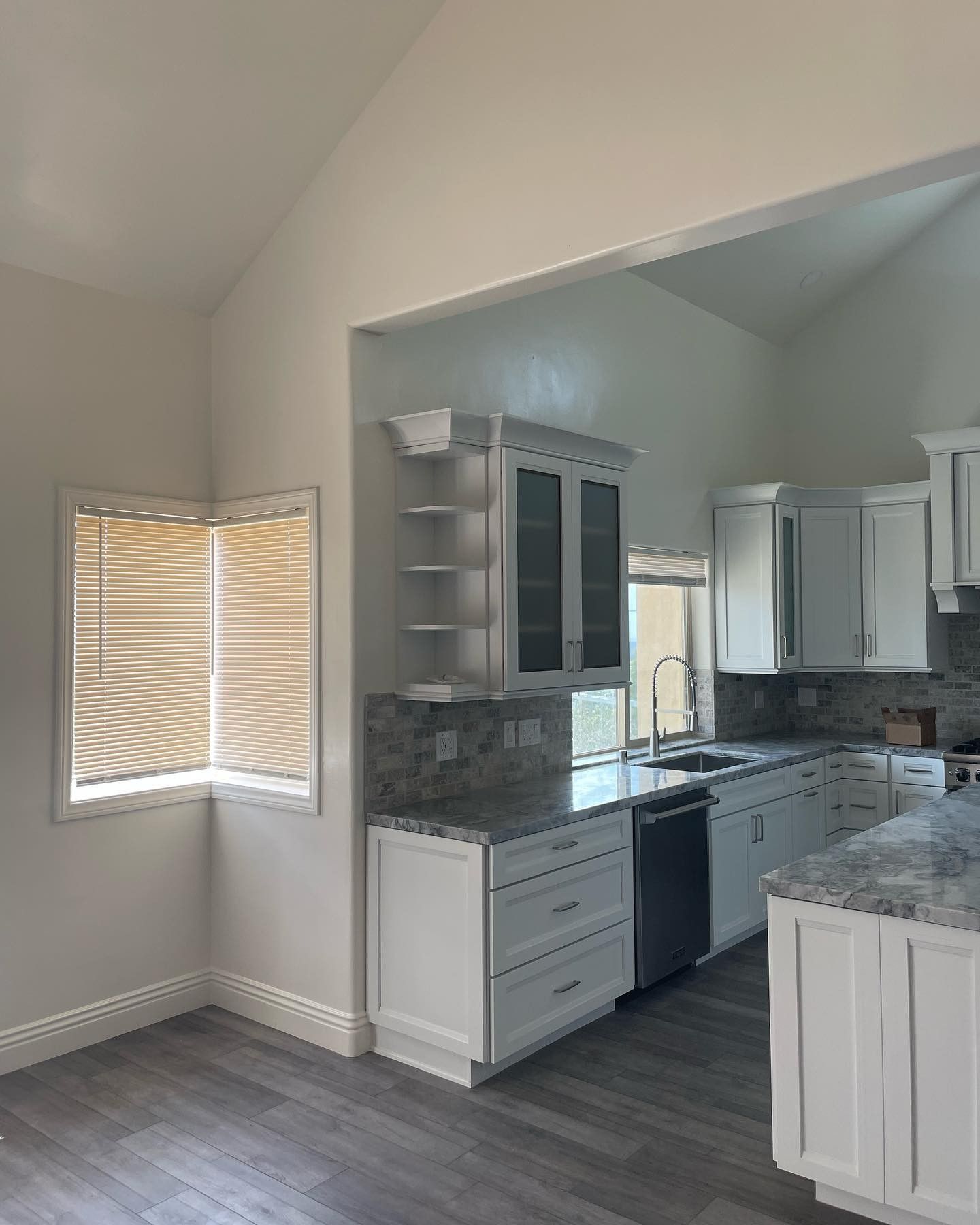 A kitchen with white cabinets and granite counter tops