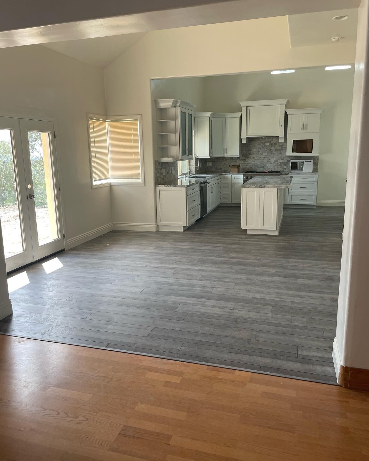A kitchen with a wooden floor and white cabinets