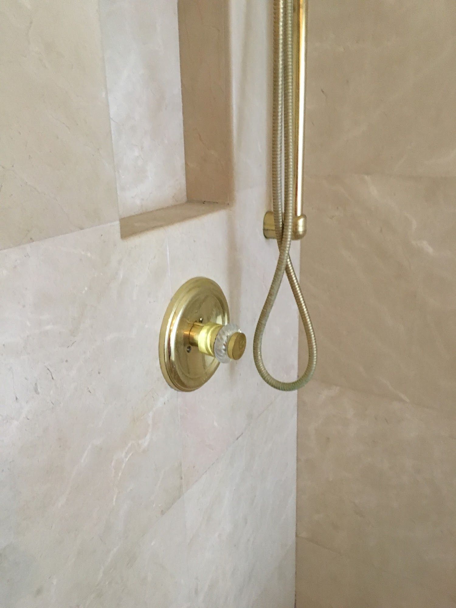 A close up of a shower head in a bathroom.
