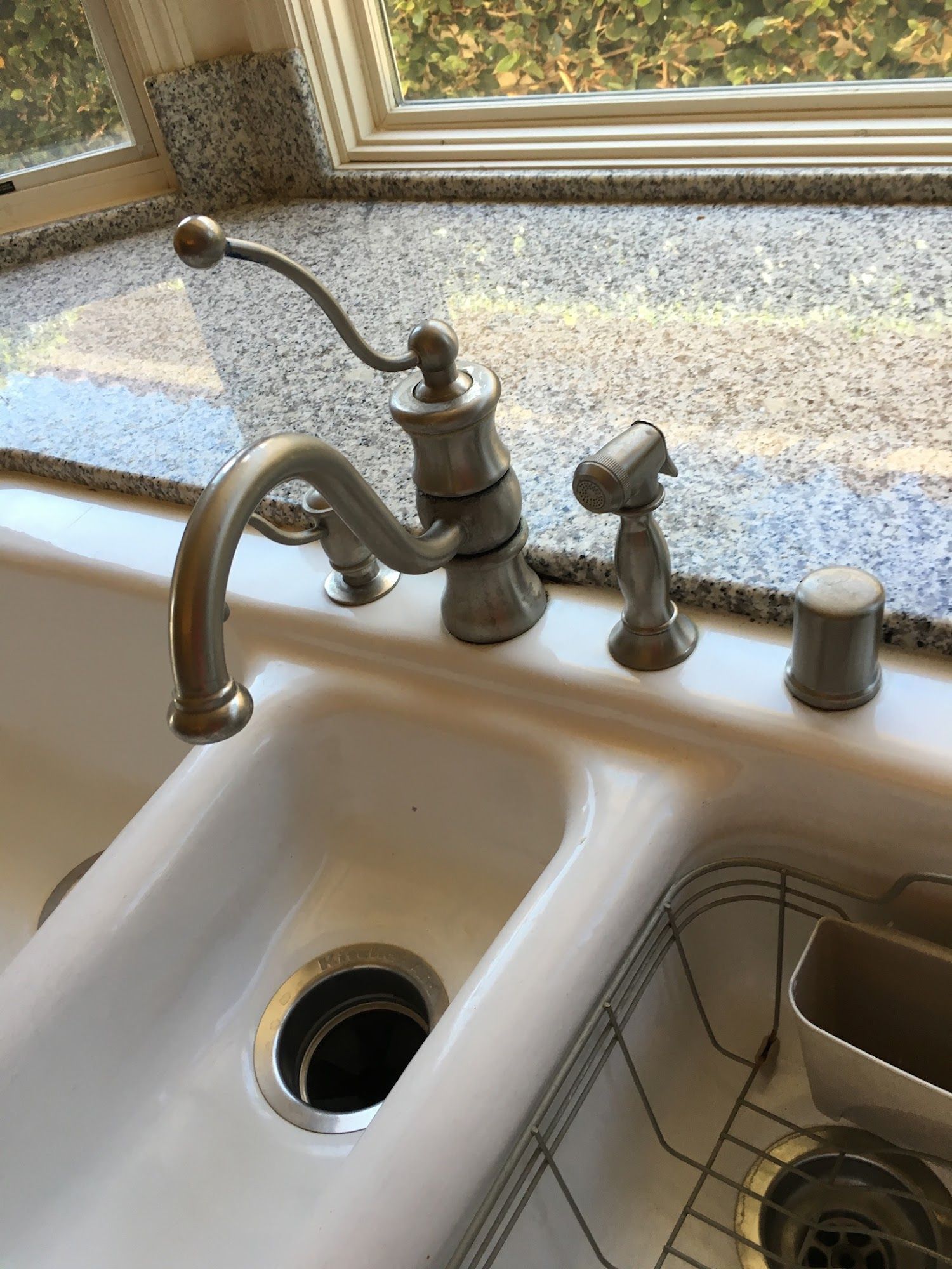 A kitchen sink with a faucet and soap dispenser on the counter.