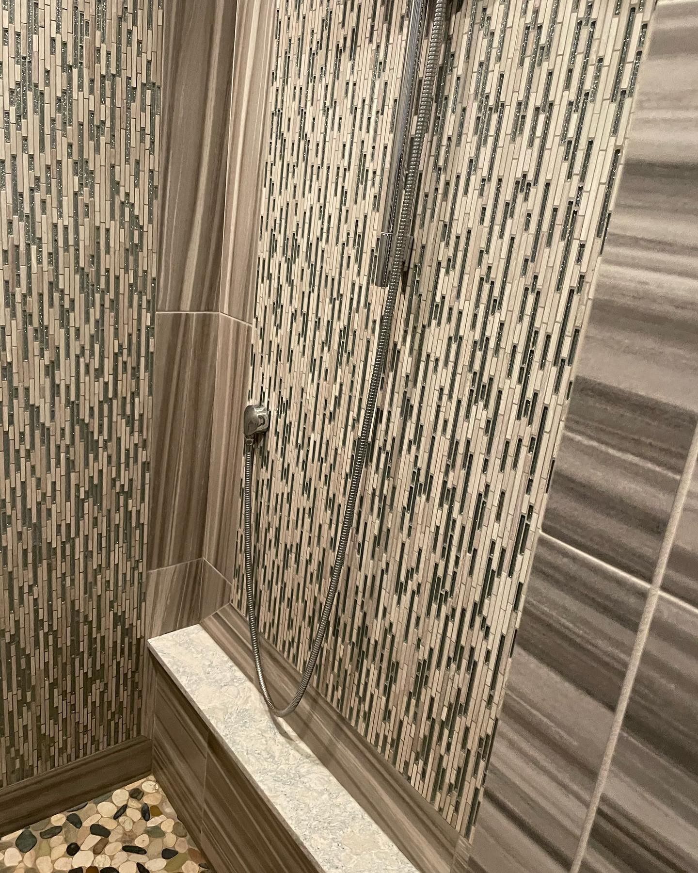 A bathroom with a walk in shower and a tiled wall.