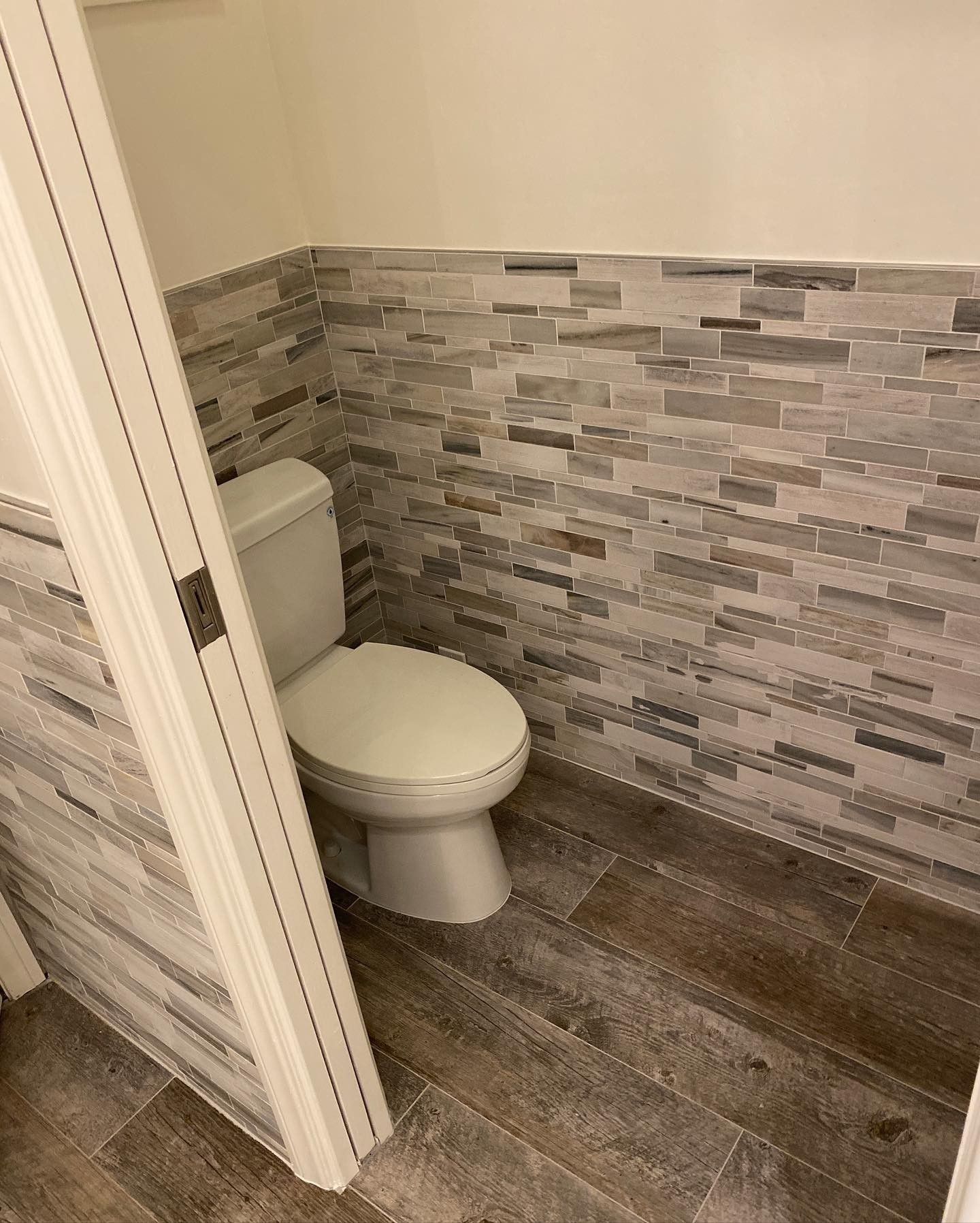 A toilet is sitting in a bathroom next to a door.