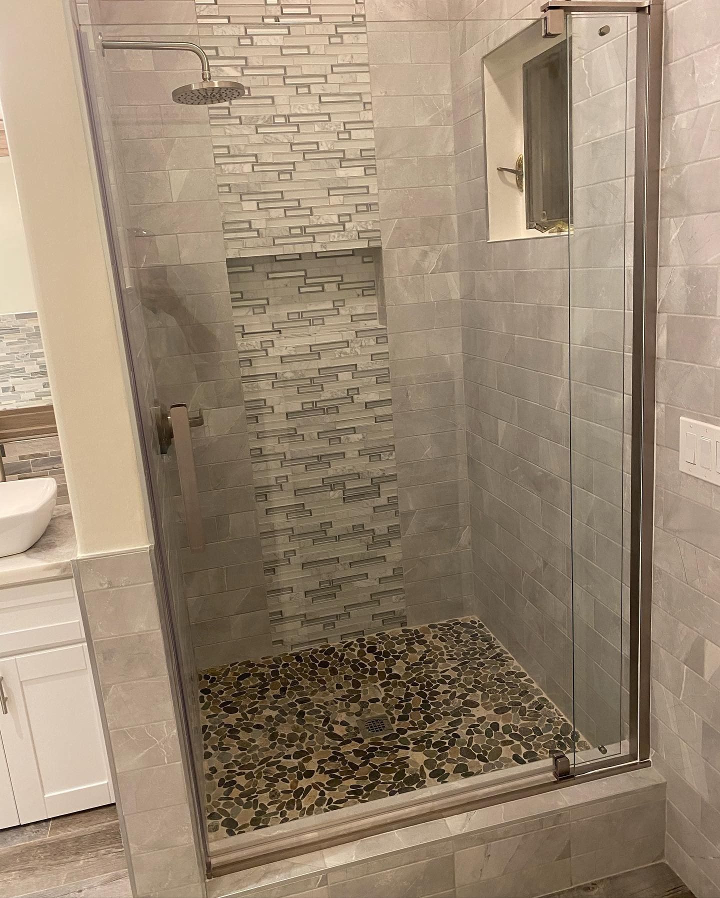 A bathroom with a walk in shower and a sink.