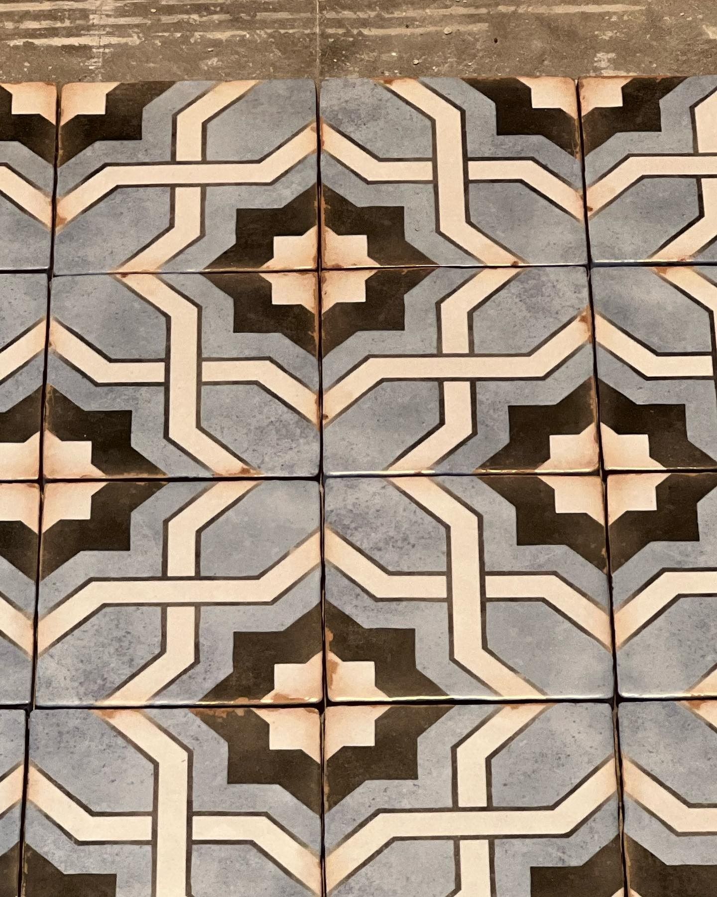 A close up of a tile floor with a geometric pattern