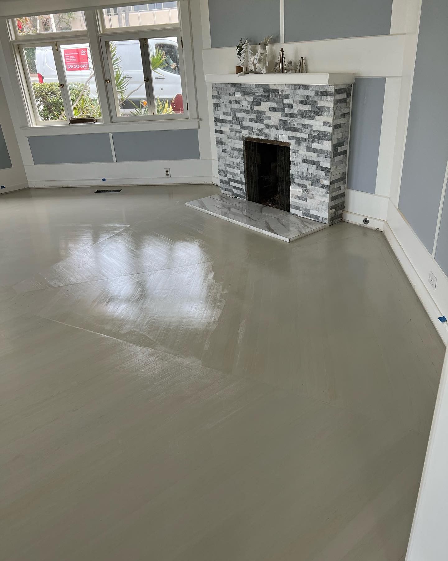 A living room with a fireplace and a concrete floor.