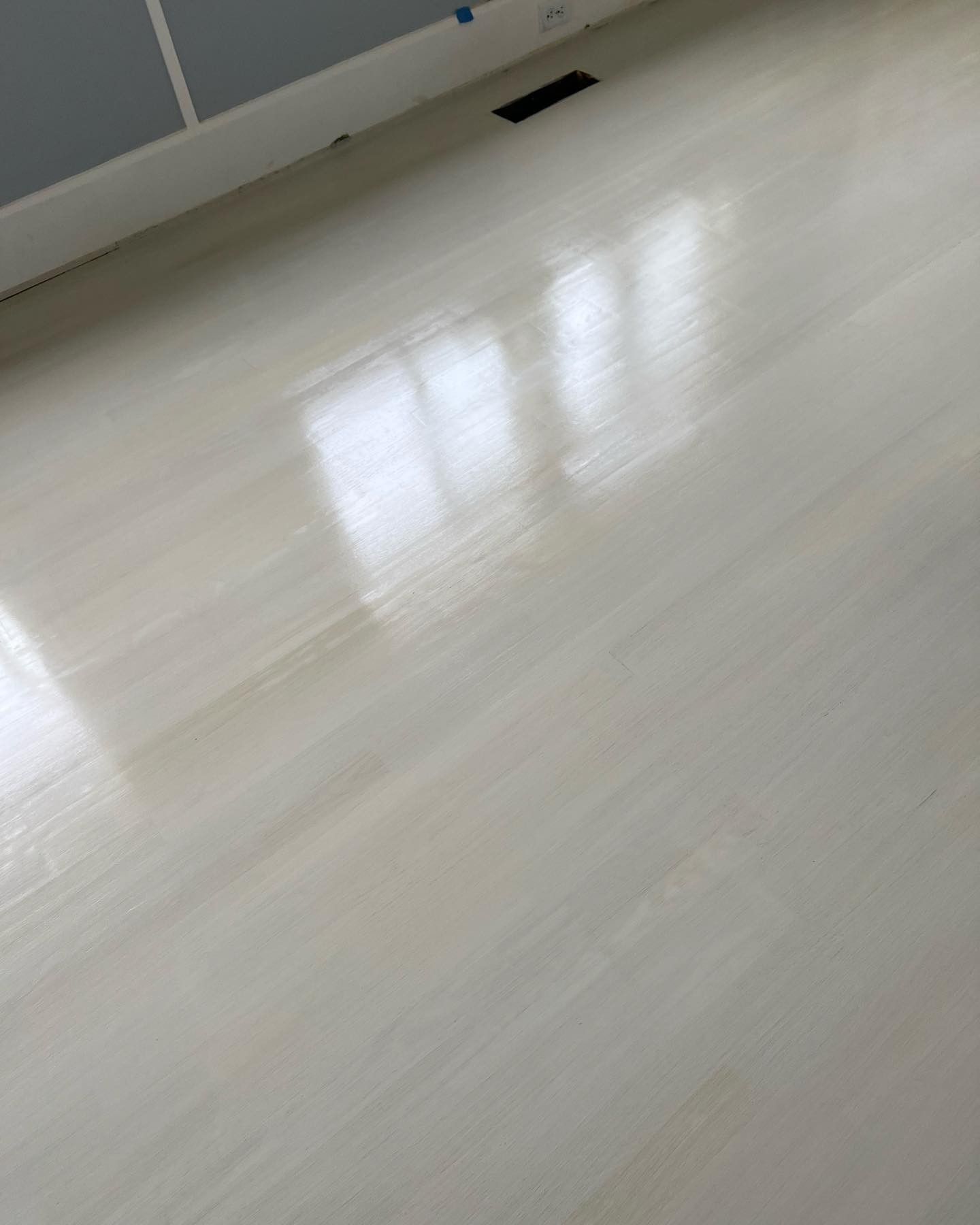 A close up of a white wooden floor in a room.