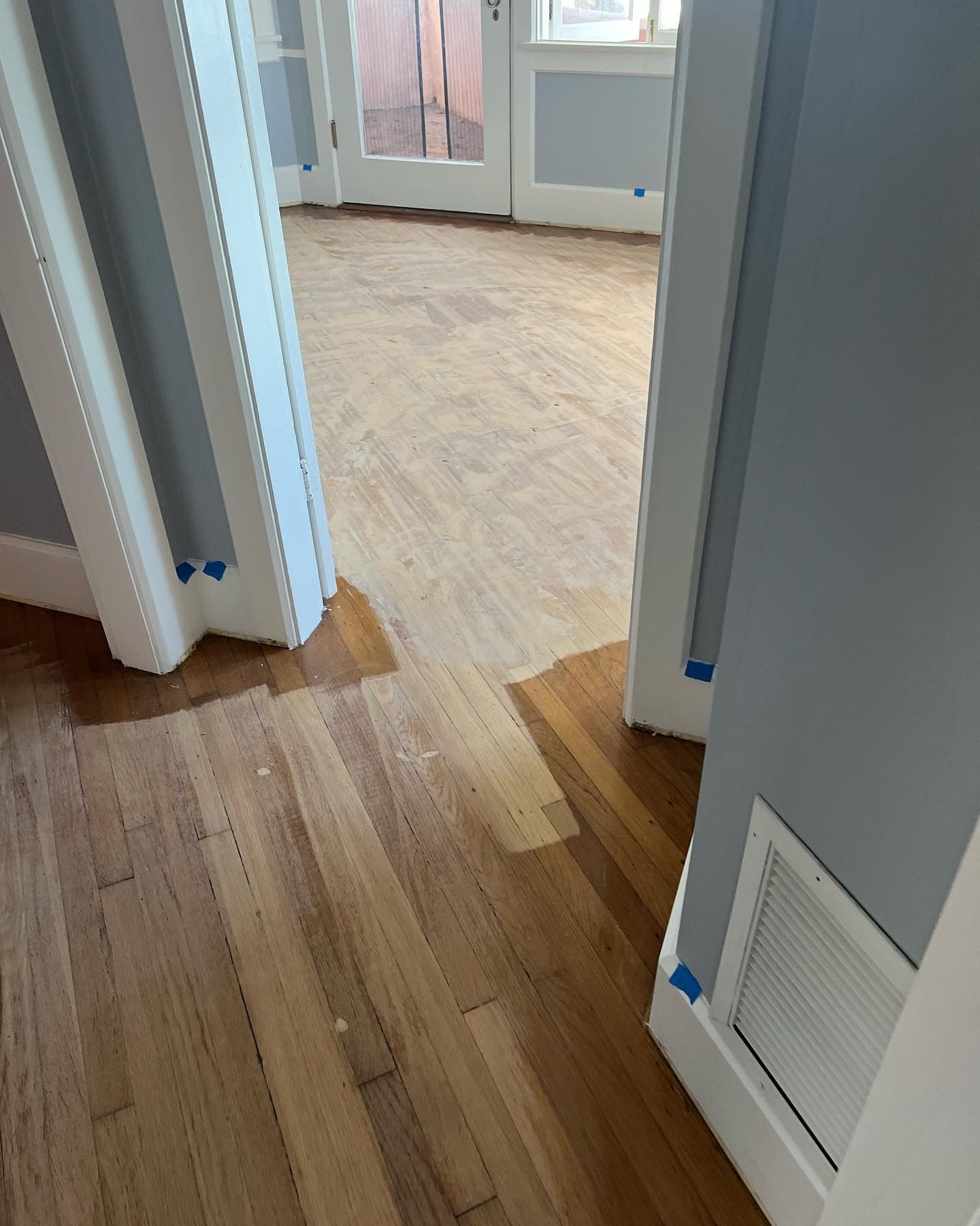 A hallway with hardwood floors and a sliding glass door