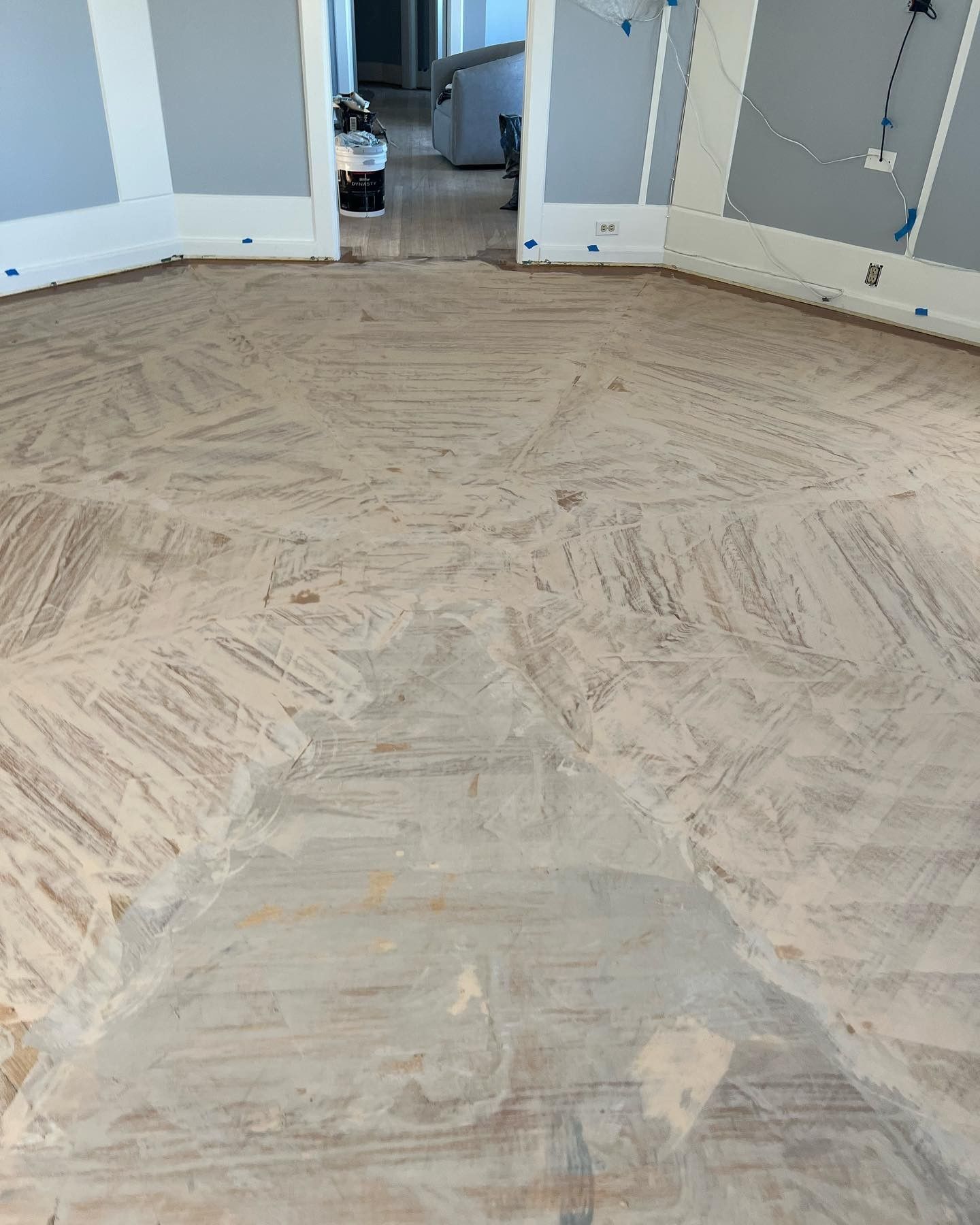 A wooden floor in a room with a herringbone pattern.