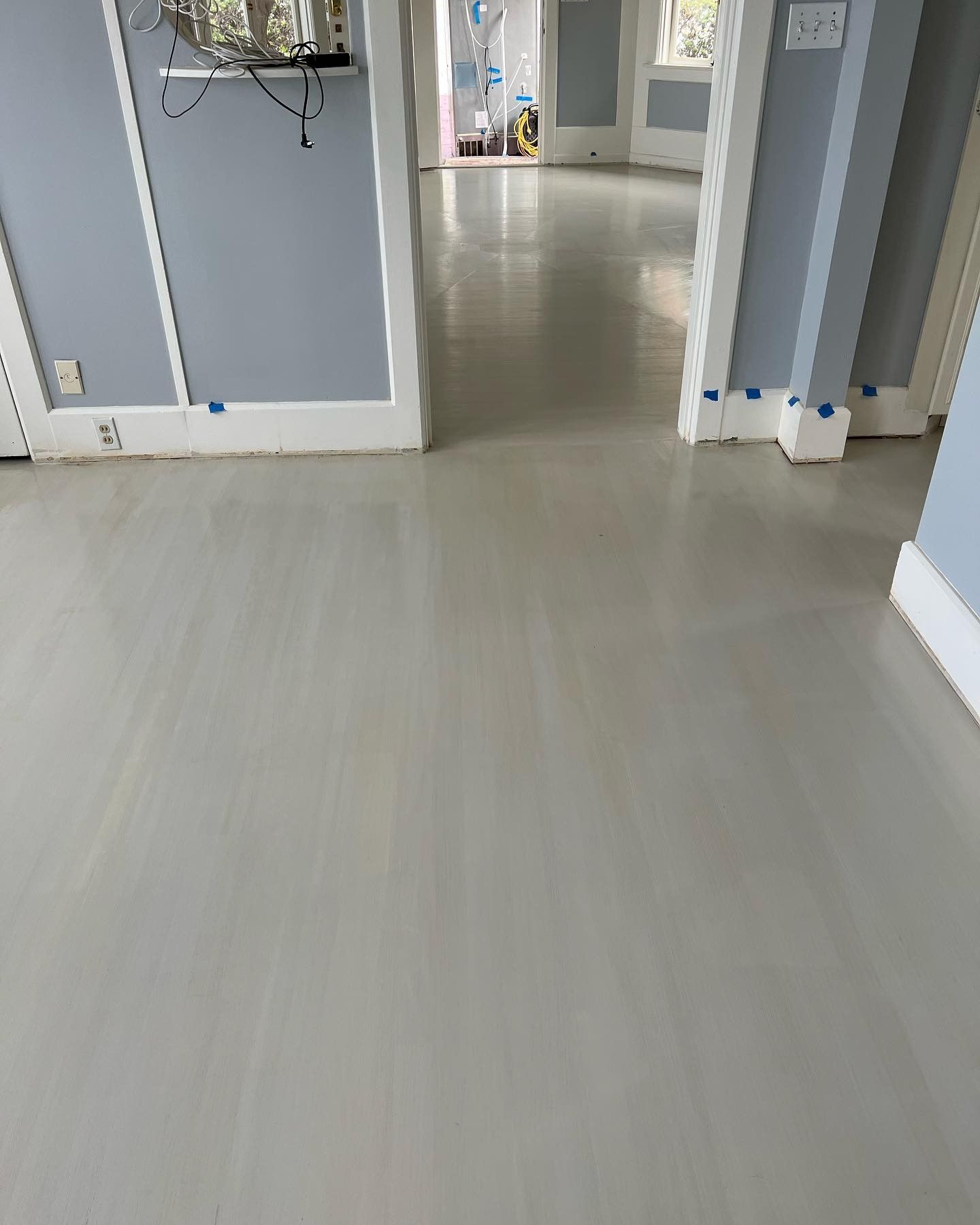 A hallway with a white floor and blue walls.