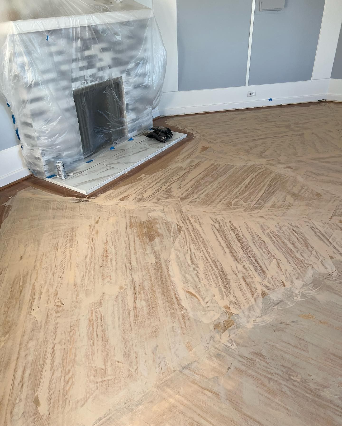 A living room with a fireplace and a wooden floor.