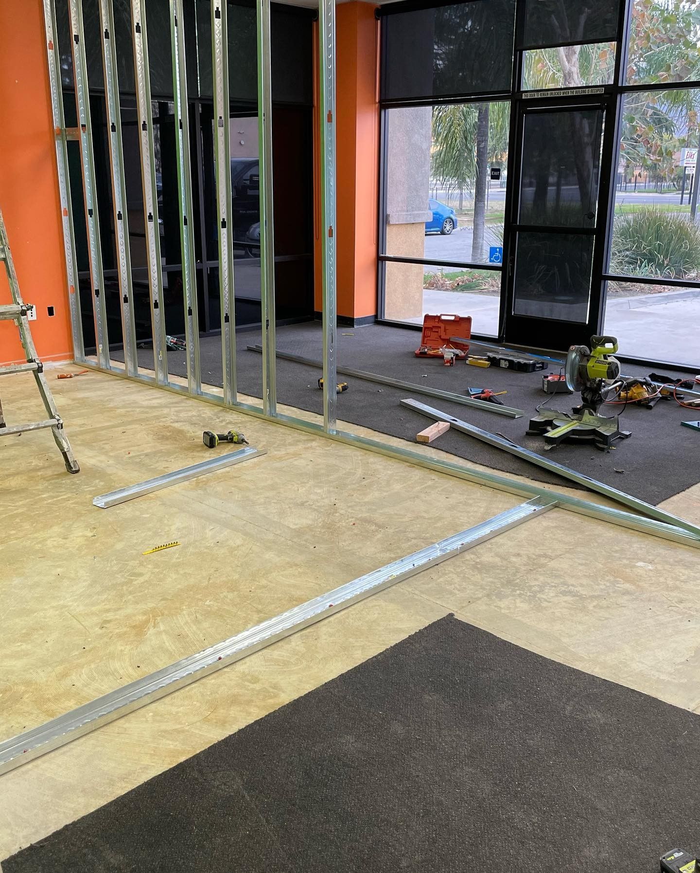 A room with a ladder and a lot of tools on the floor.