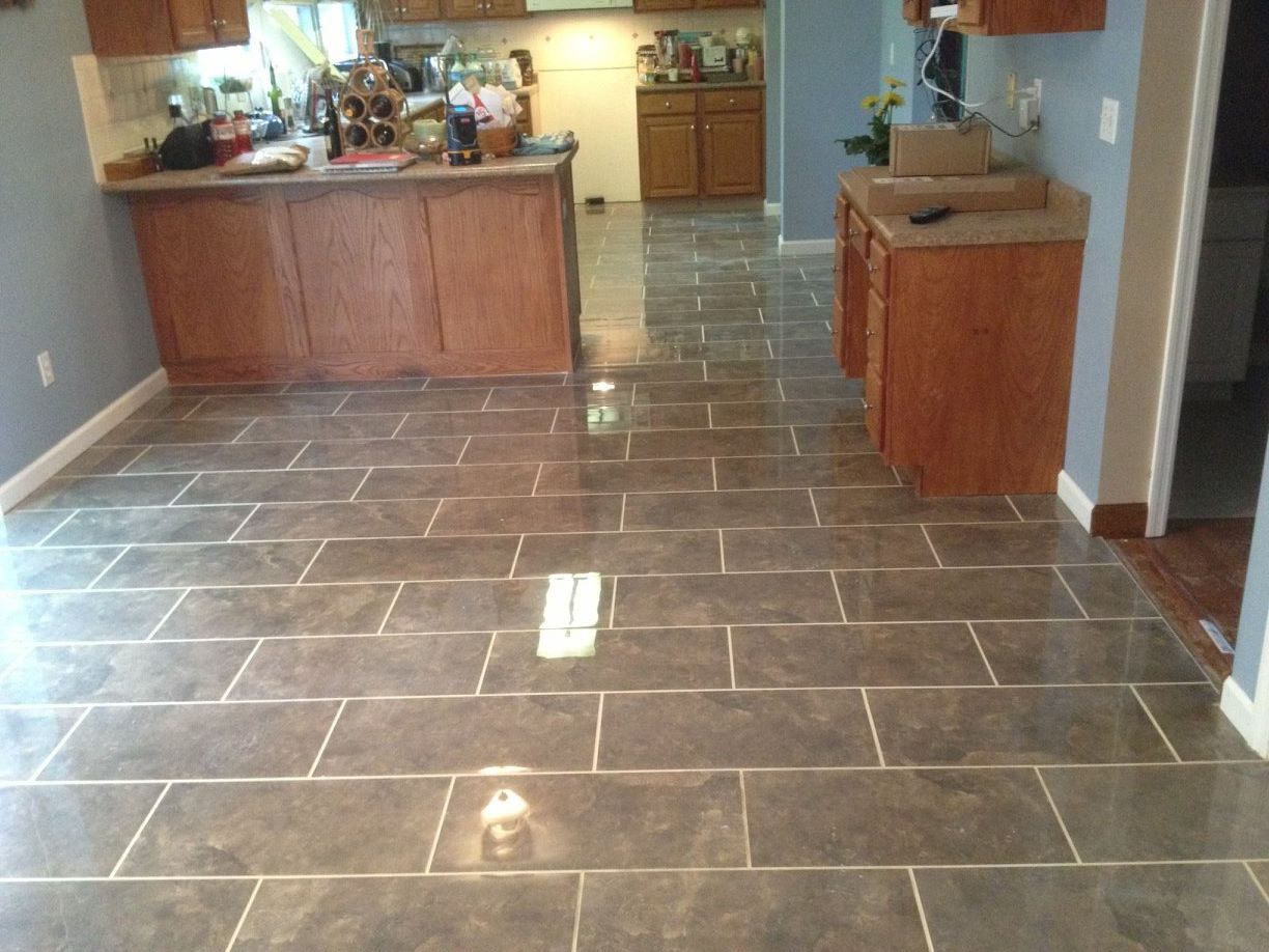 A kitchen with a tiled floor and wooden cabinets