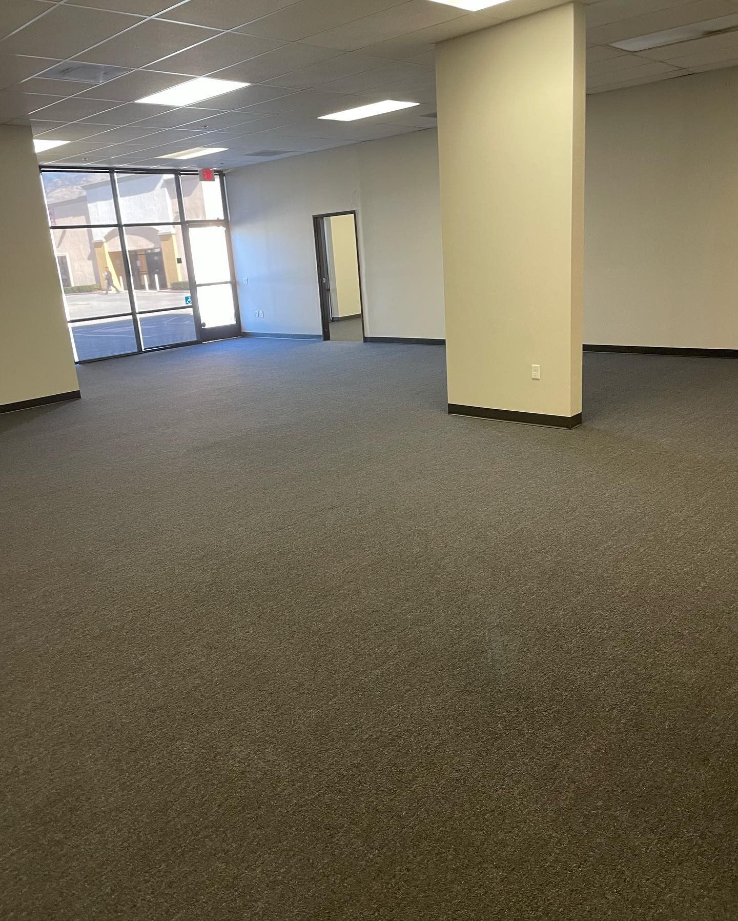 An empty room with a gray carpet and white walls