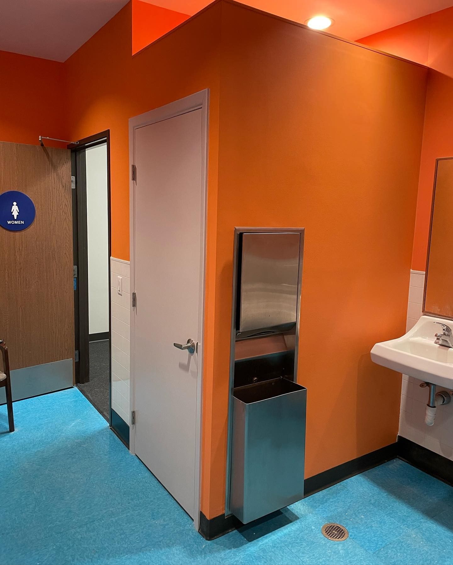A bathroom with orange walls and a sink.
