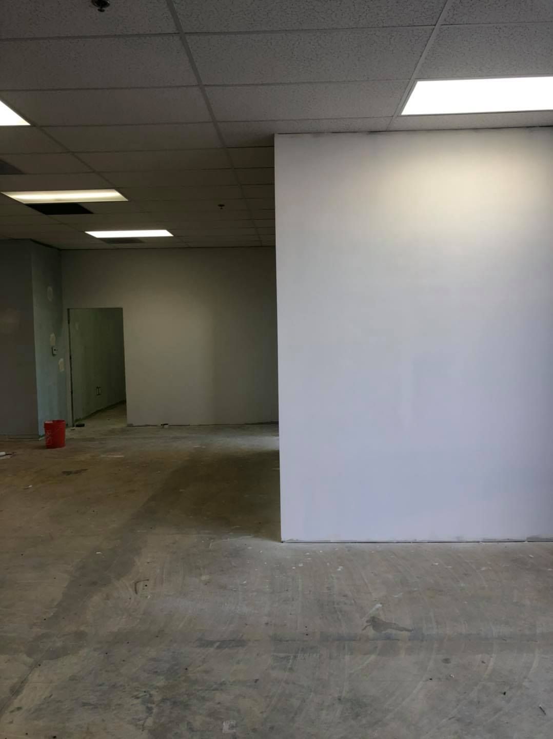 An empty room with white walls and a concrete floor