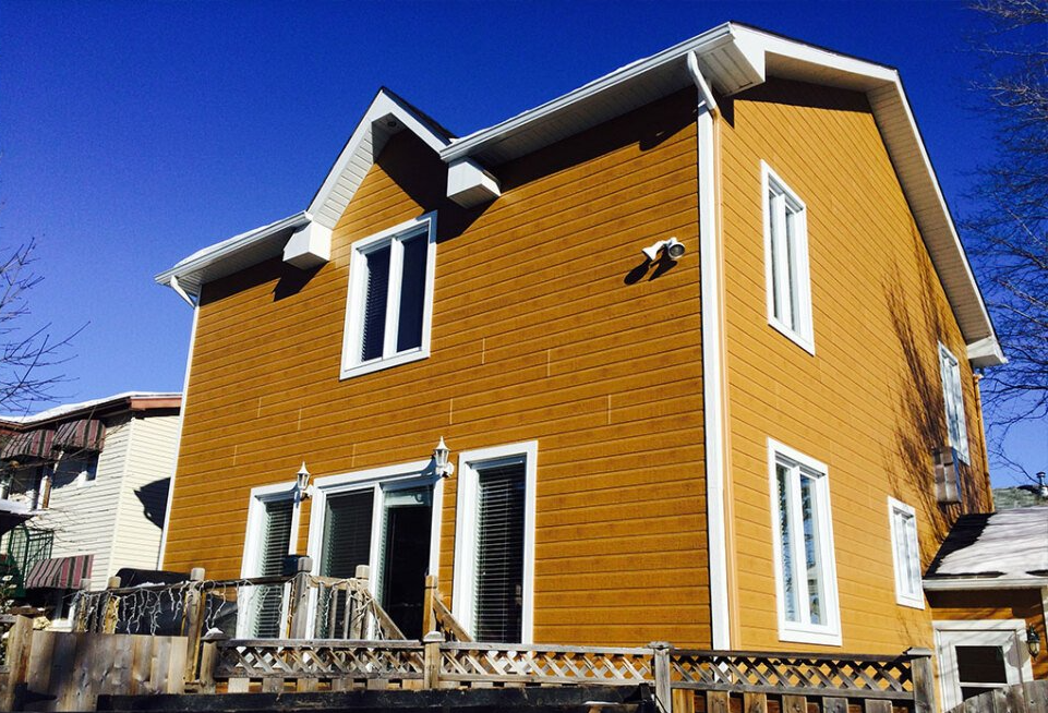 Une grande maison jaune avec un ciel bleu en arrière-plan