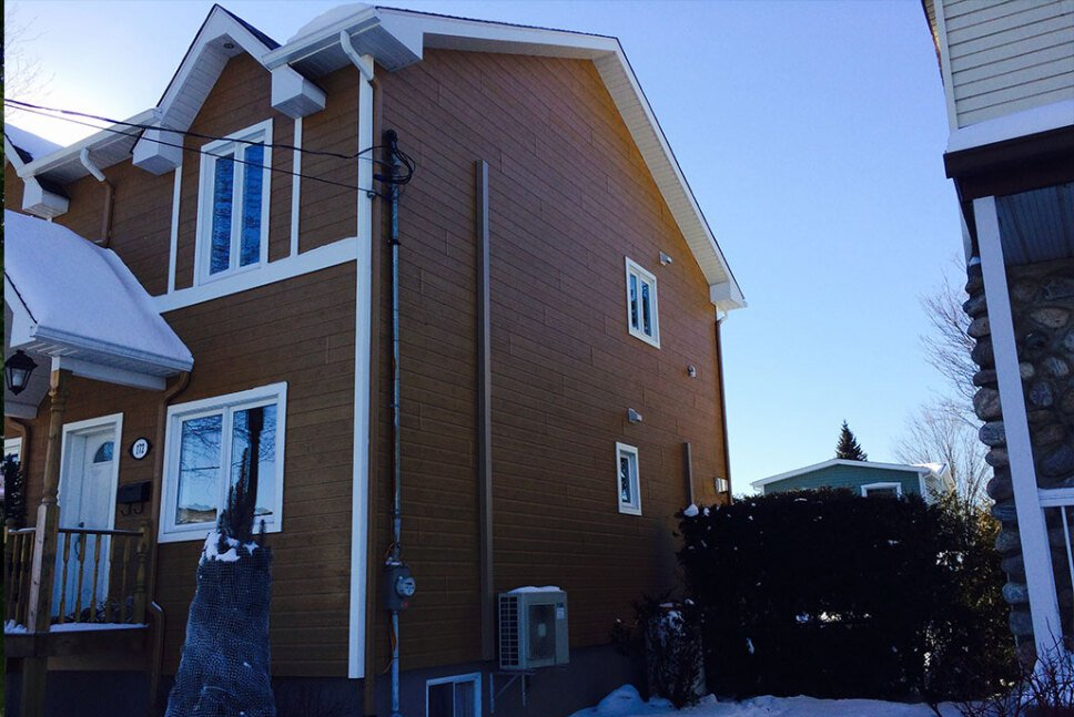 Une maison avec beaucoup de fenêtres et de la neige au sol