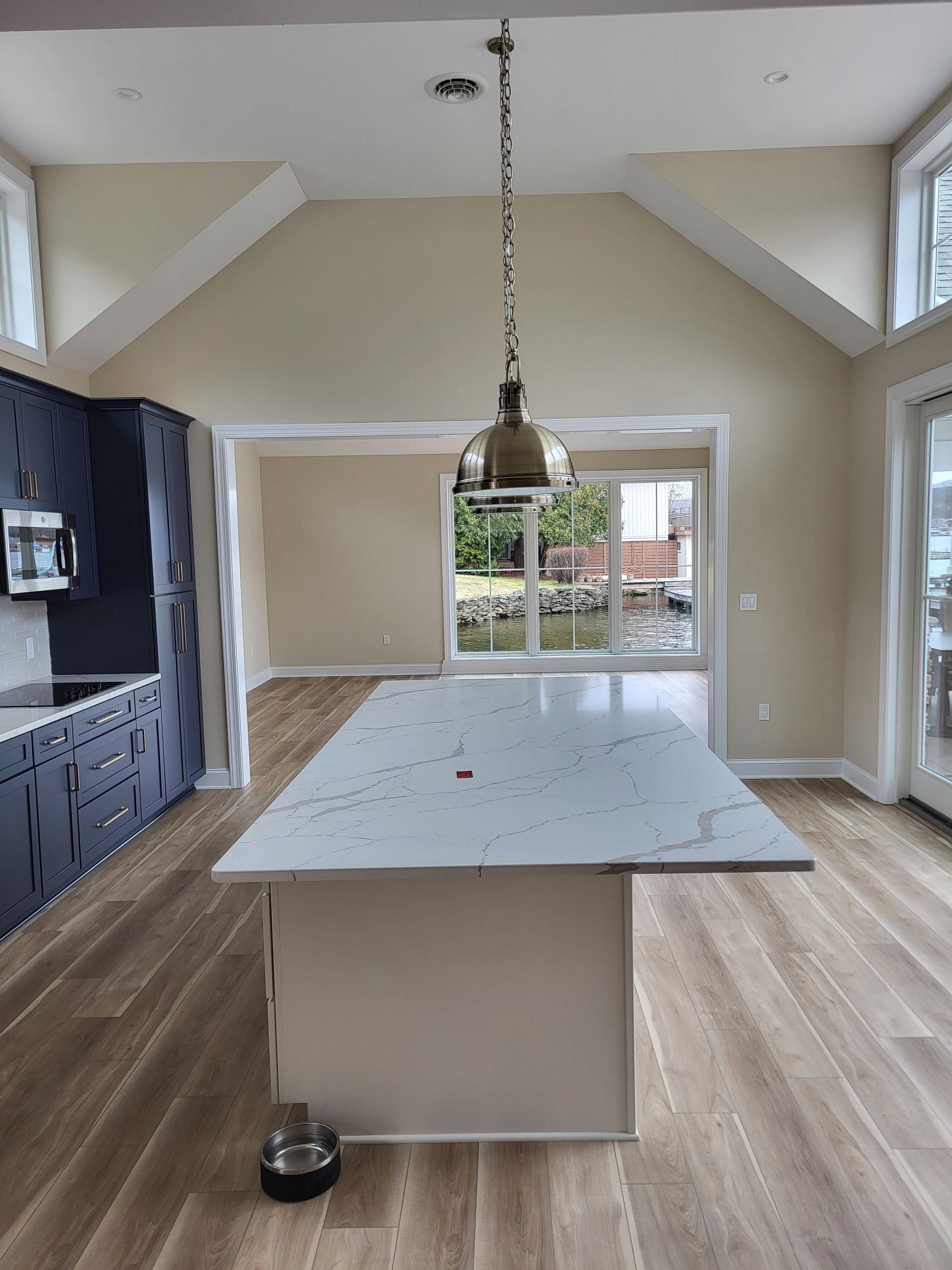 An empty kitchen with a large island in the middle of the room.