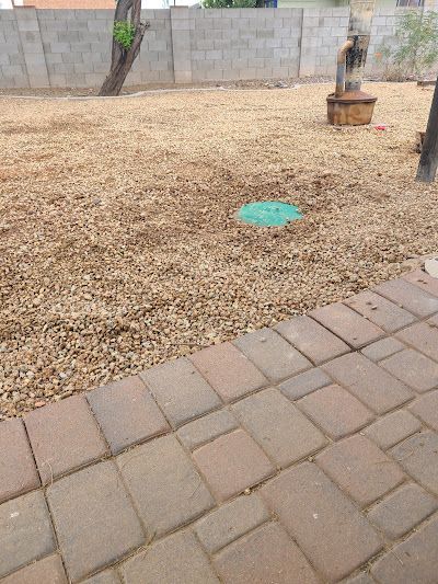A brick walkway leading to a yard with a green circle in the middle of it.