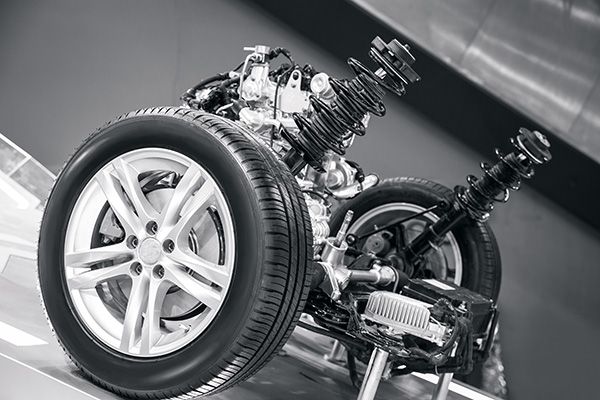 A black and white photo of a car engine and suspension. | Lex Brodies