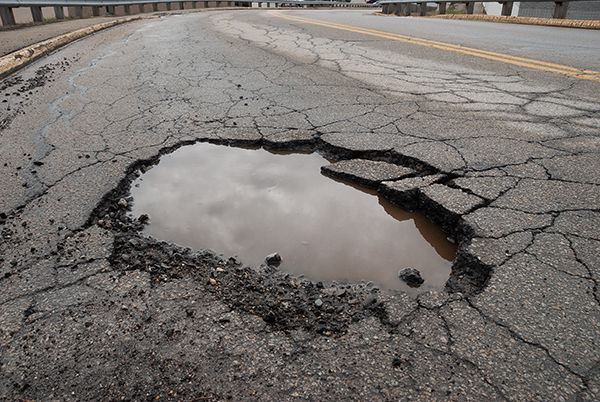 A large pothole in the middle of a road | Lex Brodies