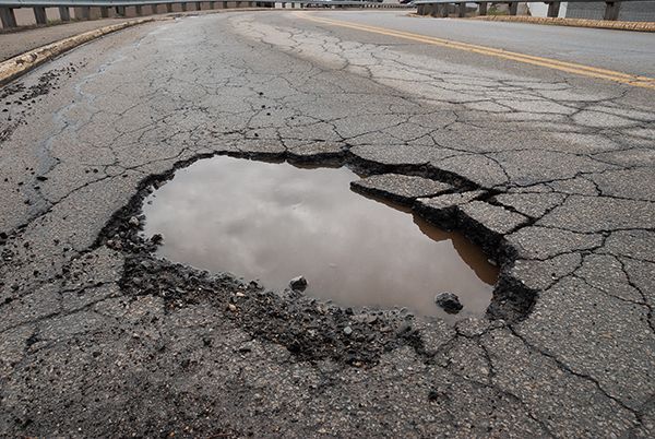 A large pothole in the middle of a road  | Lex Brodies 