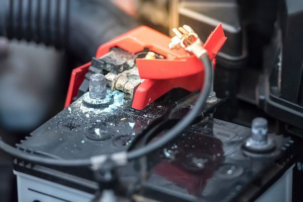 A car battery is sitting under the hood of a car. | Lex Brodies 