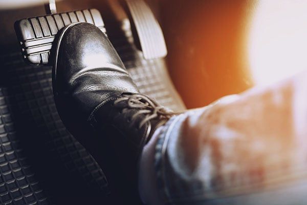 A person is pressing the brake pedal of a car. | Lex Brodies