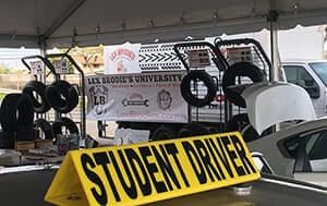 A yellow sign on top of a car that says `` student driver ''. | Lex Brodies 