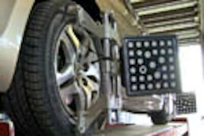 A car is being aligned with a machine in a garage. | Lex Brodies