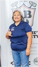 A woman in a blue shirt and jeans is giving a thumbs up. | Lex Brodies