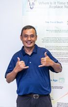 A man in a blue shirt is giving a thumbs up. | Lex Brodies