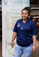 A woman is standing in front of a sign that says 