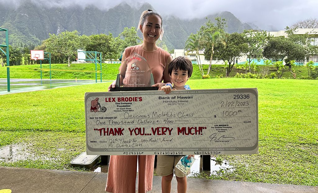 A woman and child are holding a large check that says thank you very much. | Lex Brodies
