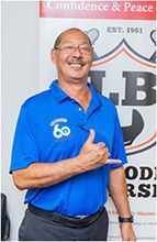 A man in a blue shirt is giving a thumbs up. | Lex Brodies