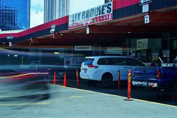 A parking lot with cars parked in front of a restaurant called lex broule 's | Lex Brodies 