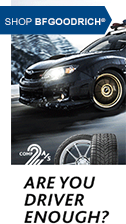 A car is driving down a road next to a tire. | Lex Brodies