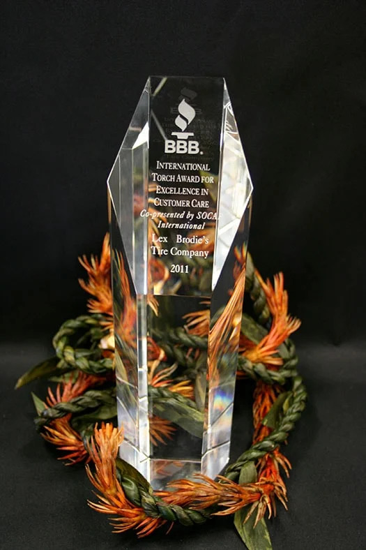 A trophy is sitting on top of a wreath of flowers on a table. | Lex Brodies