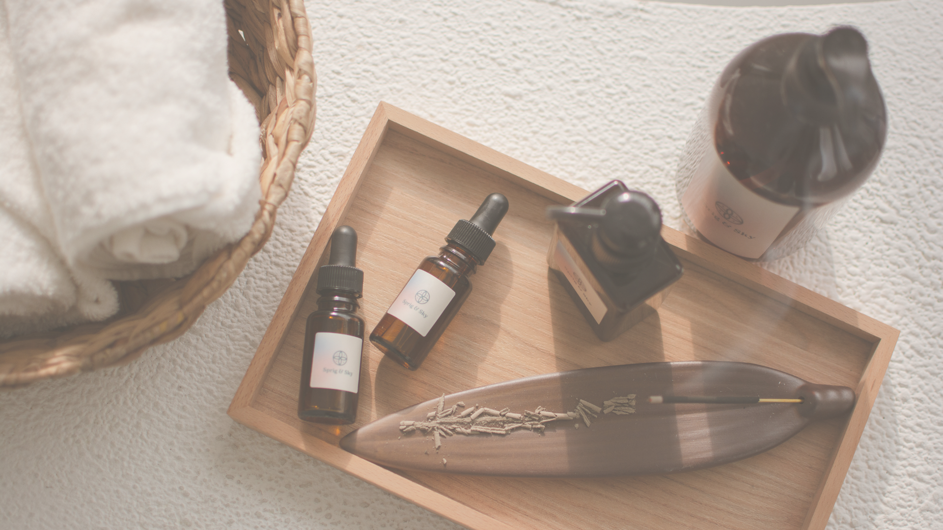 A wooden tray with bottles of essential oils and incense on it.
