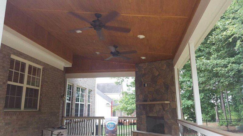 A porch with a ceiling fan and a fireplace