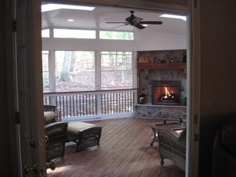 A living room with a fireplace and a ceiling fan
