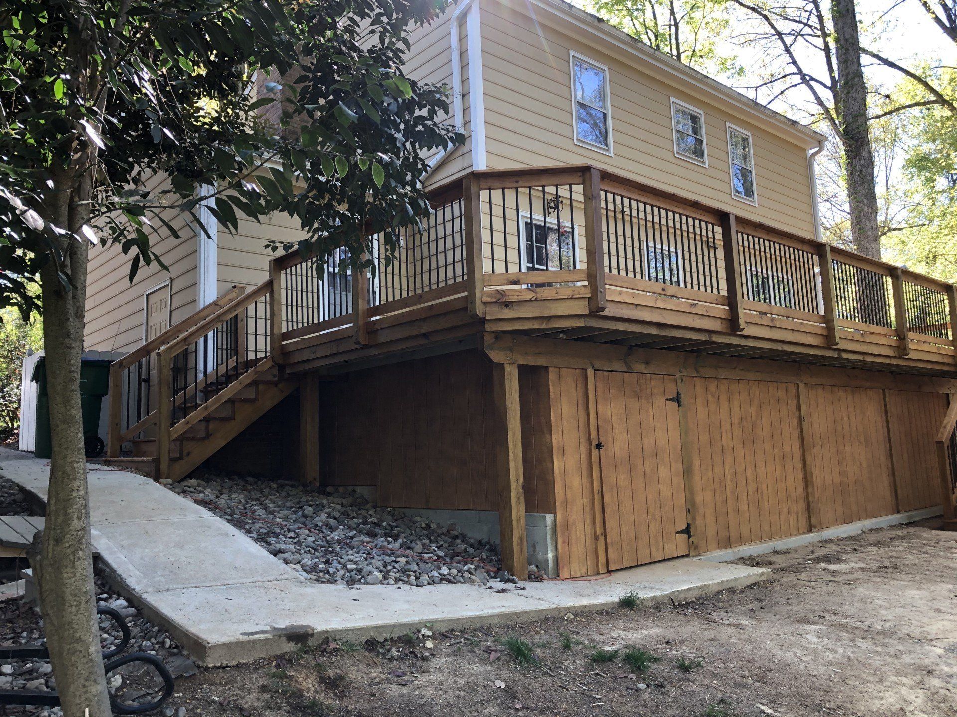 A house with a large wooden deck on the side of it.